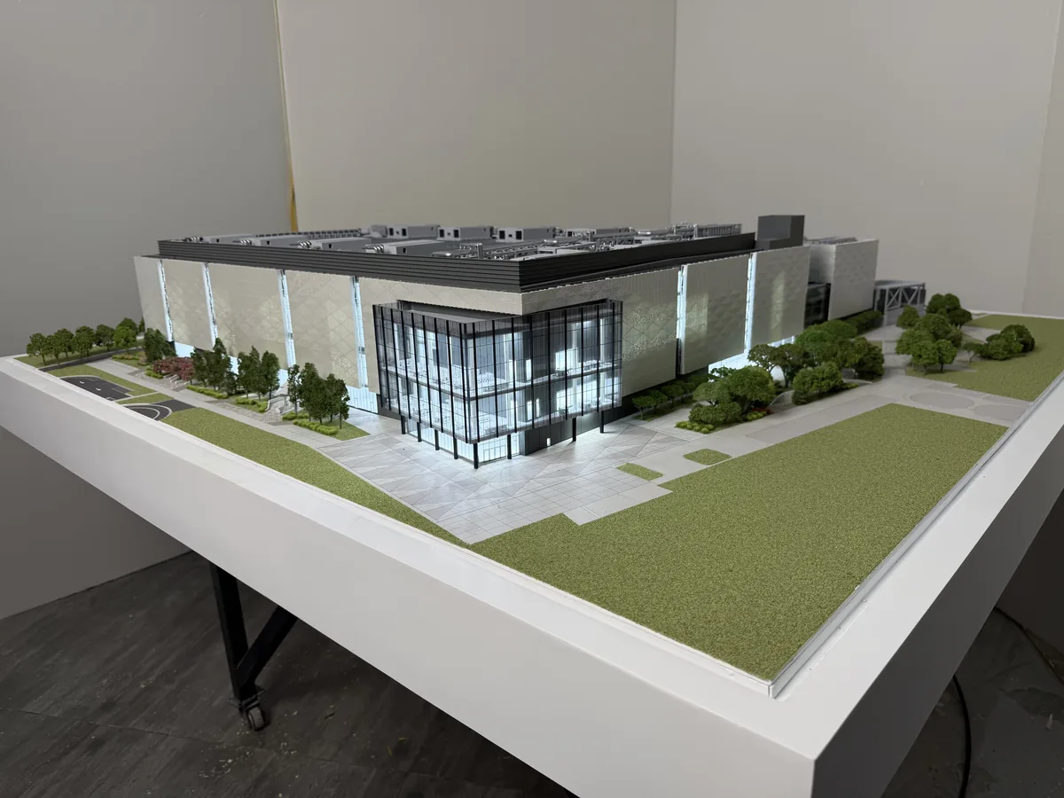 Illuminated exterior of a 1:200 laboratory and R&D campus model with glazed atrium and landscaping